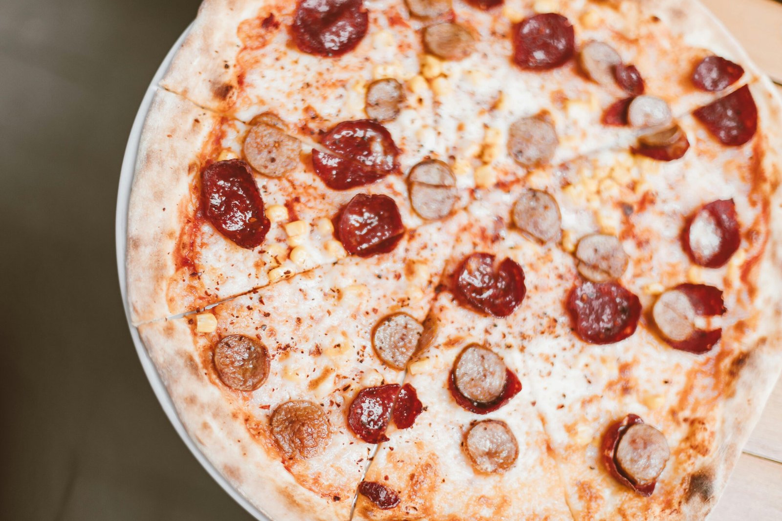 Mouth-watering pepperoni and sausage pizza photographed from above.